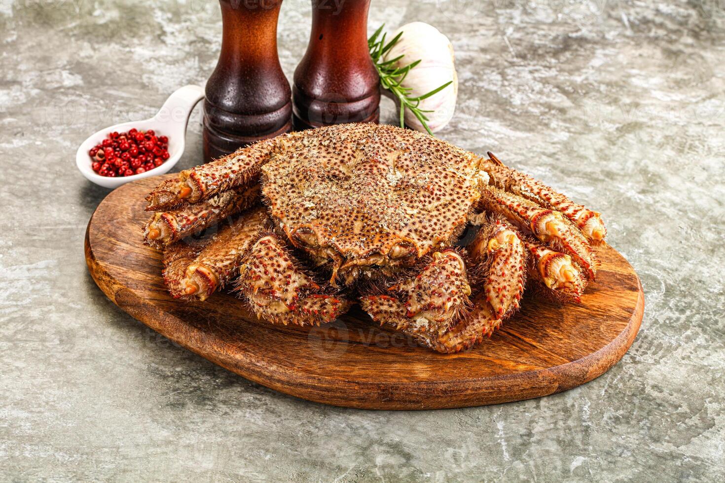 A crab on a wooden board with two bottles of ketchup photo