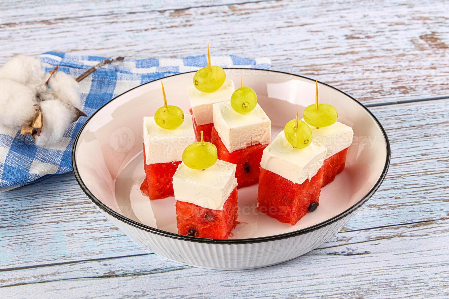 A white bowl with watermelon and cheese on it photo