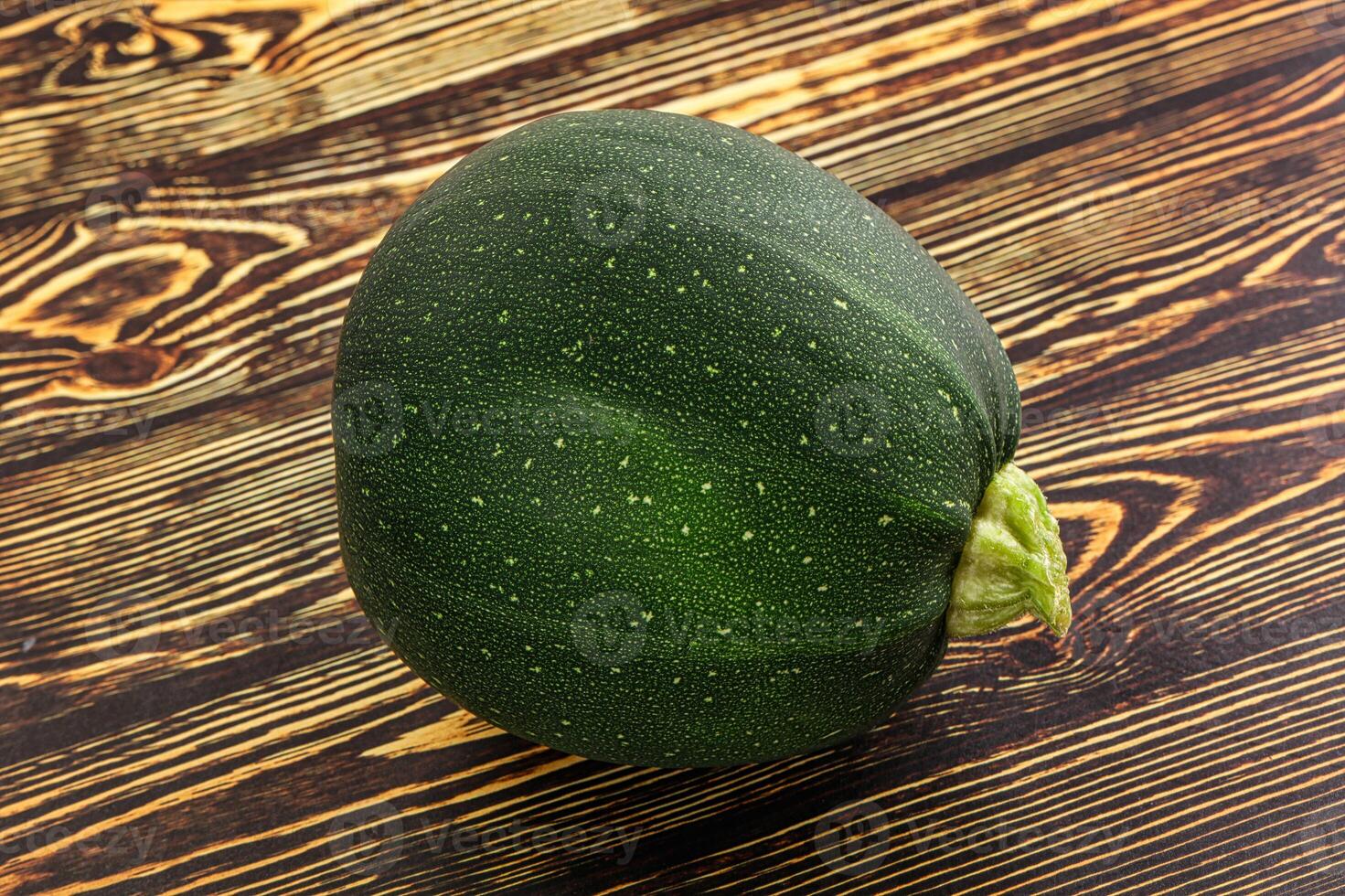 A green squash on a wooden table photo