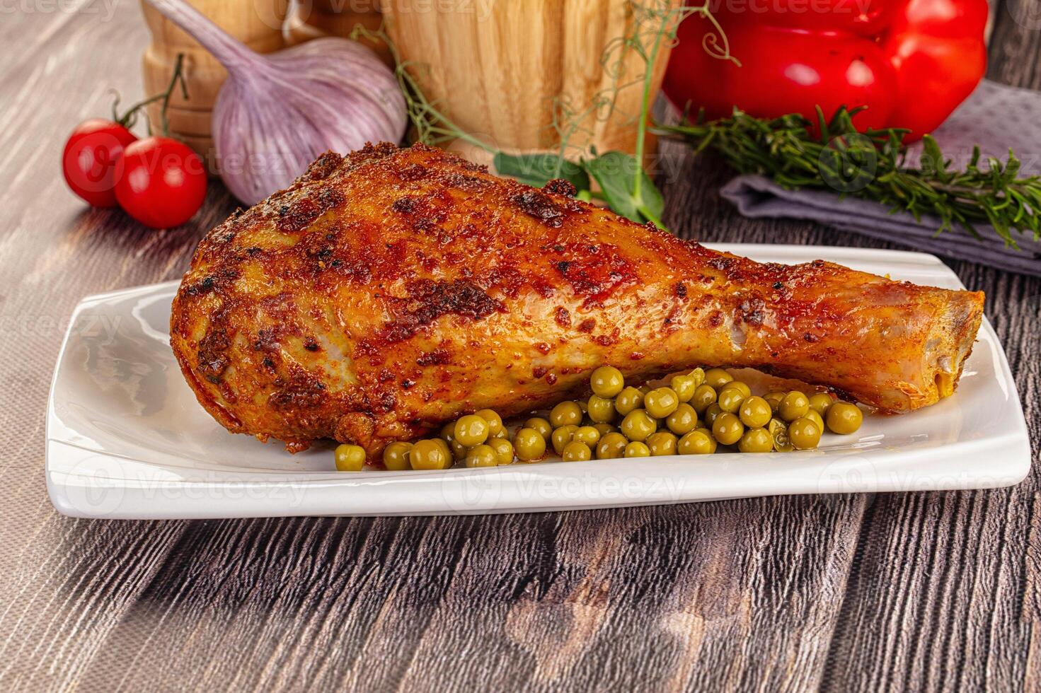 A plate with a chicken and peas on it photo