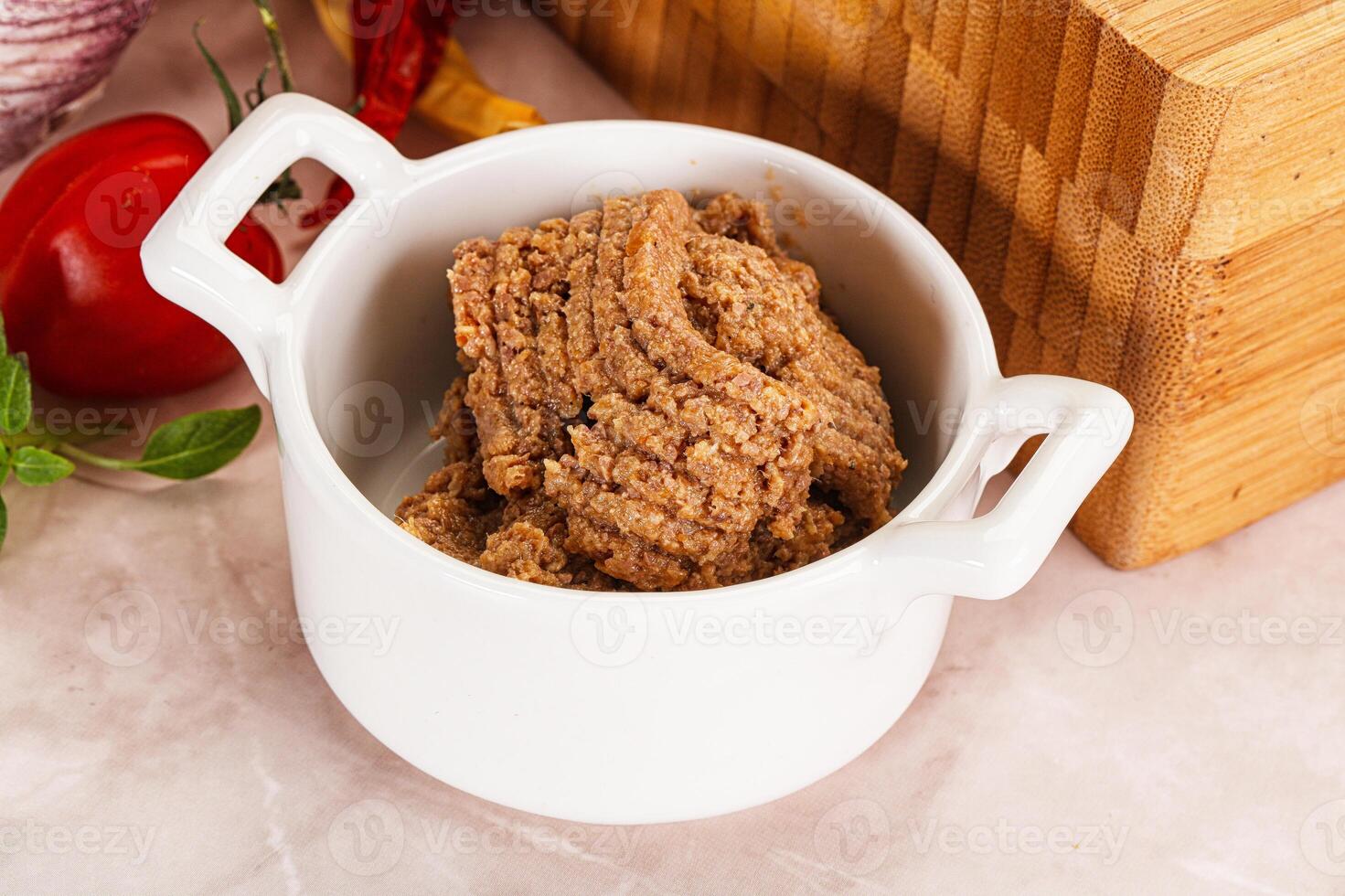 A bowl of food with a knife and a cutting board photo