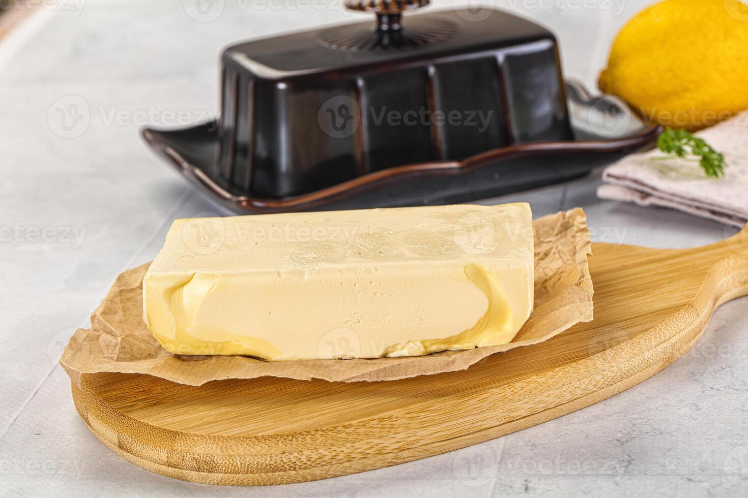 A piece of butter sitting on a cutting board photo