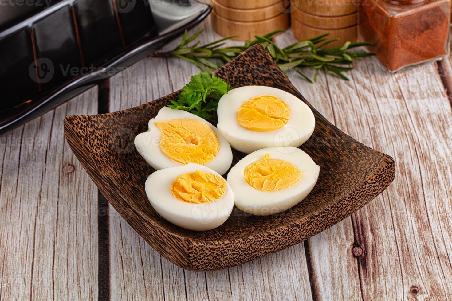 A bowl of eggs on a table next to a pan photo
