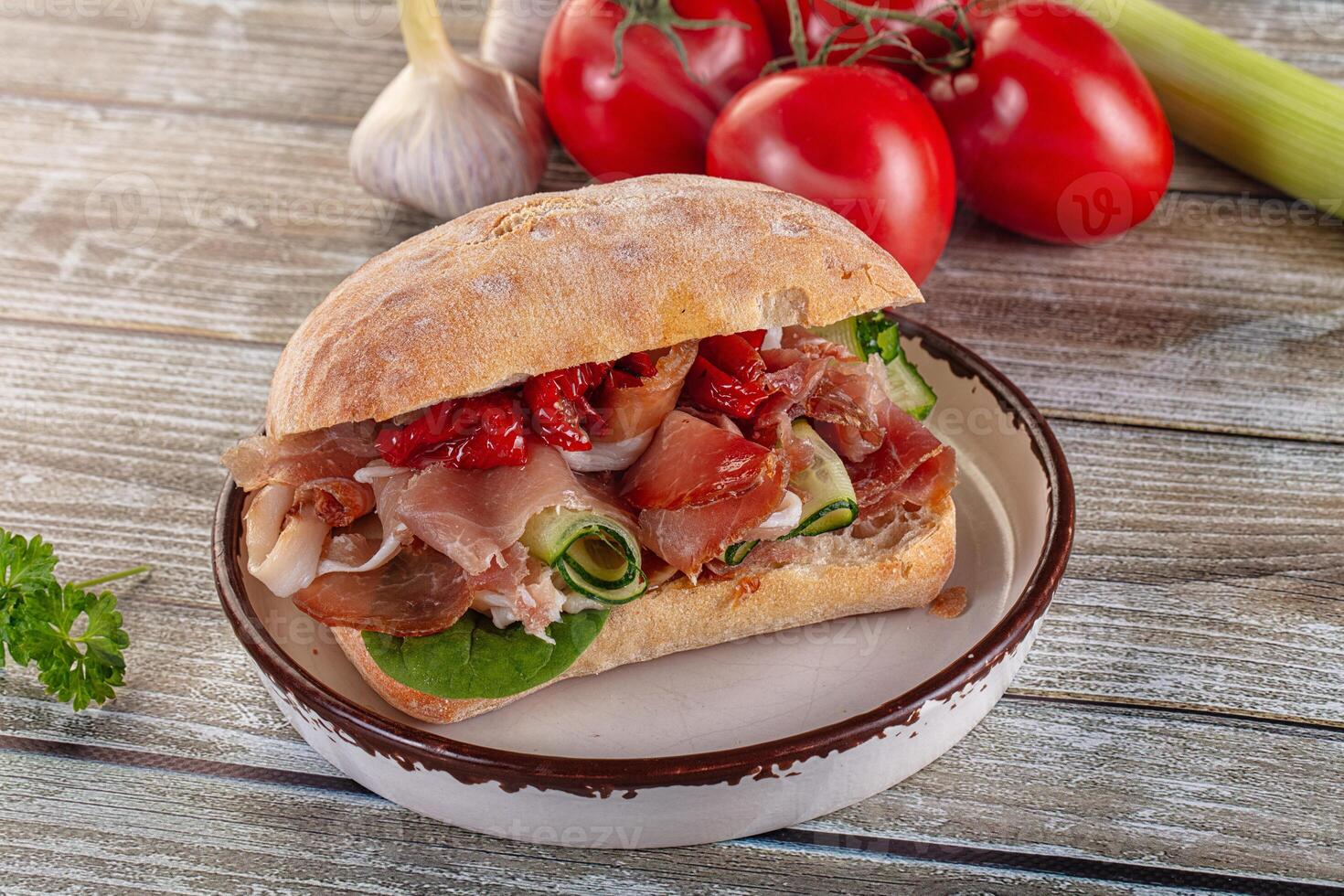 A sandwich with meat and vegetables on a plate photo