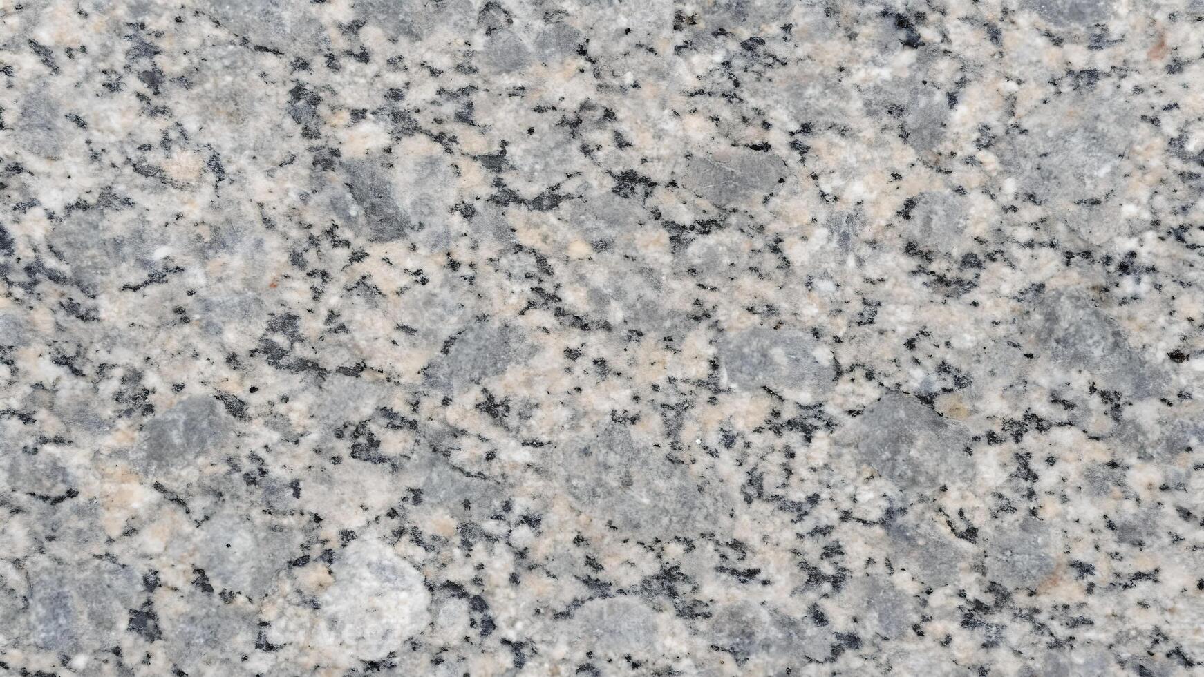 A close up of a polished granite surface showcasing a beautiful blend of gray, white, and black speckles, ideal for backgrounds or texture in design projects. photo