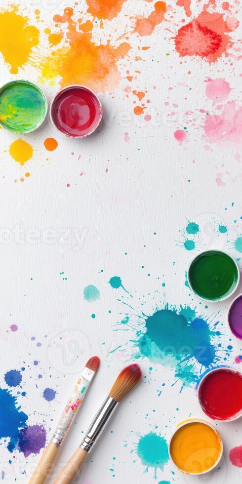Assortment of vibrant watercolors with brushes on a splattered canvas creating an artistic background photo