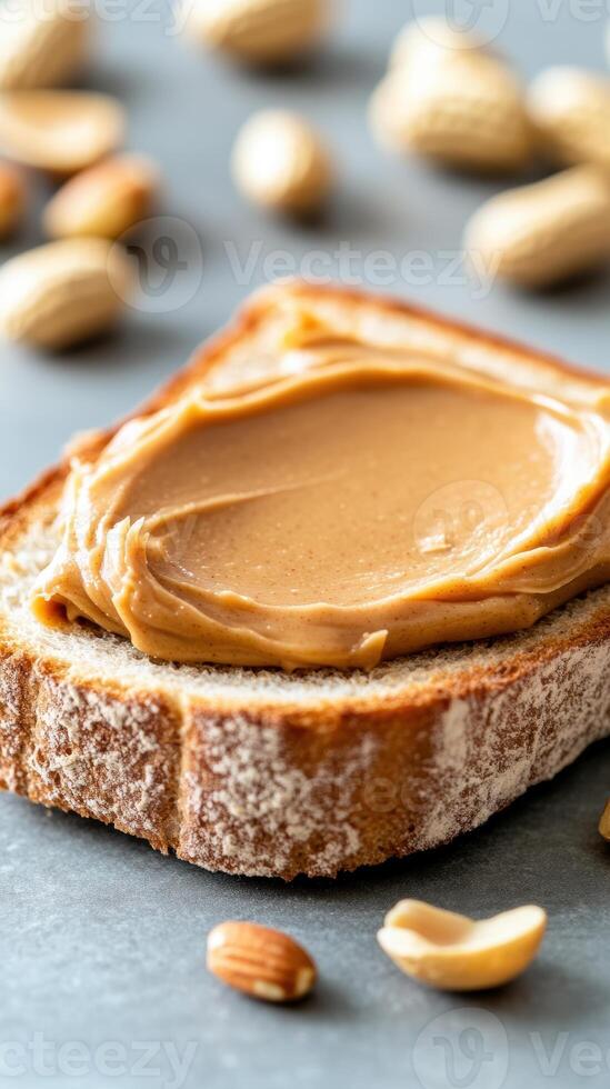 Delicious creamy peanut butter spread on fresh slice of bread with peanuts in warm rustic kitchen setting photo