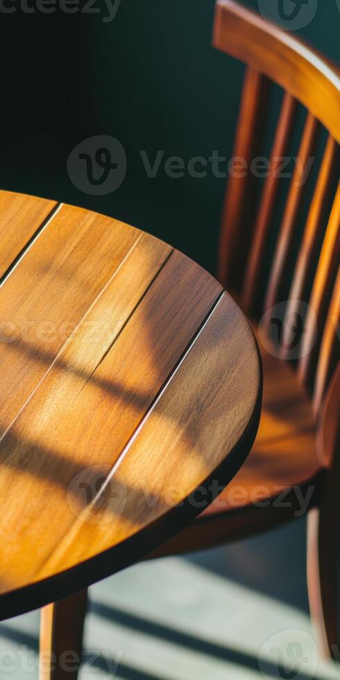 Sunlit wooden table and chair with warm tones and shadows in minimalist setting photo