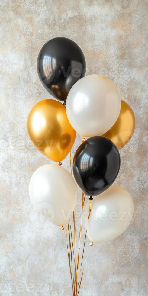Gold and black helium balloons against textured wall elegant celebration decor photo
