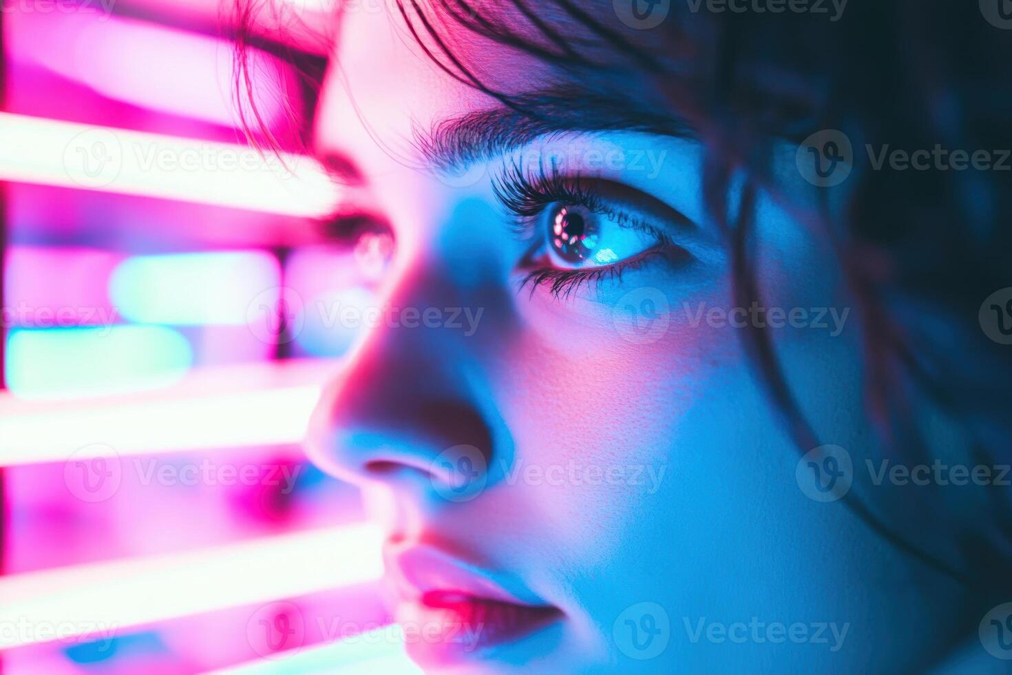 Close up of woman's face illuminated by neon lights in a vibrant urban setting photo