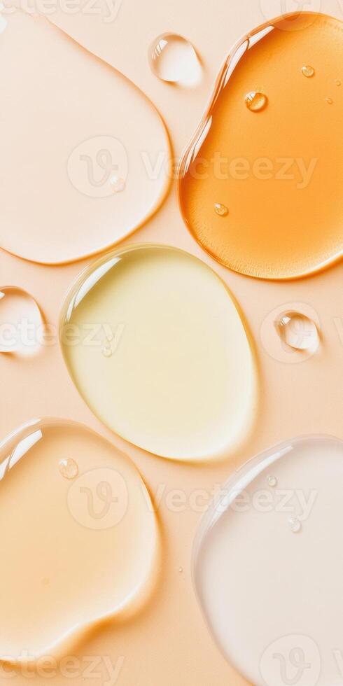 Assorted droplets of skincare serum on peach background in a variety of vibrant colors and textures photo