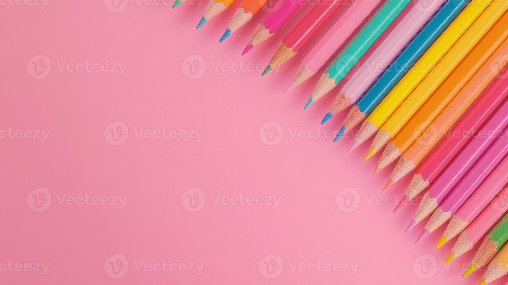 Colorful array of pencils aligned on pink background for artistic inspiration and creativity photo