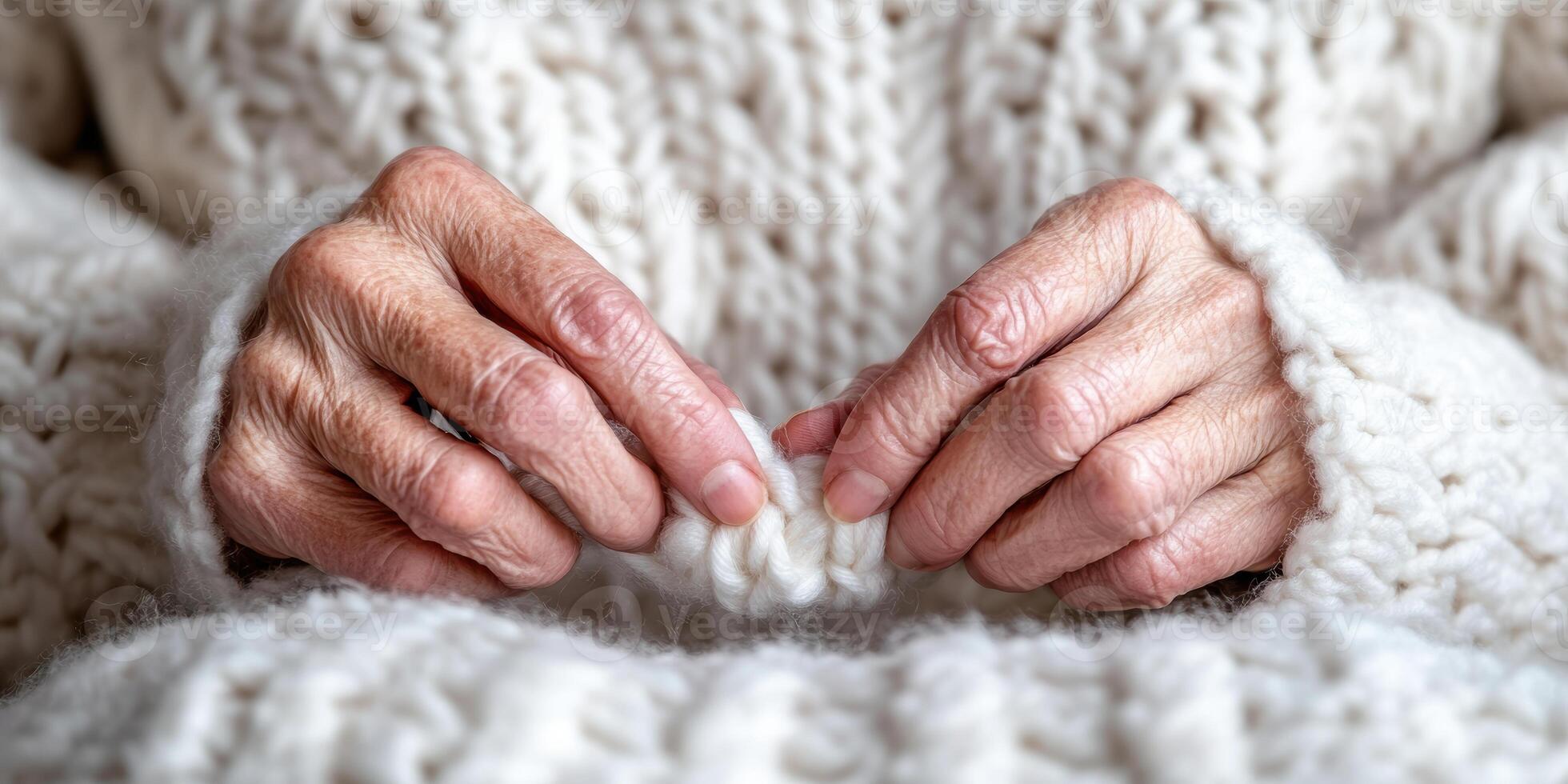 Close up of elderly hands knitting a cozy white wool sweater with care and precision photo