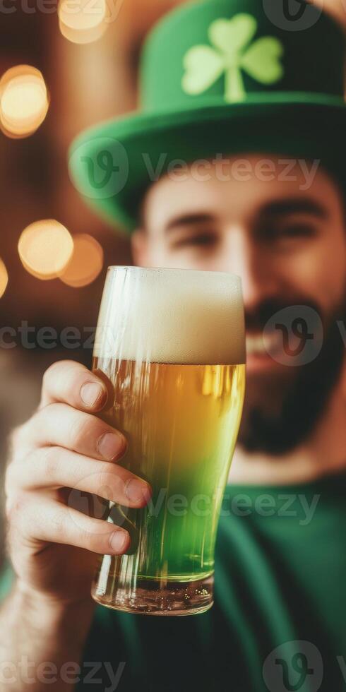Smiling man holding green beer in a festive hat celebrating st patricks day in a lively pub setting photo