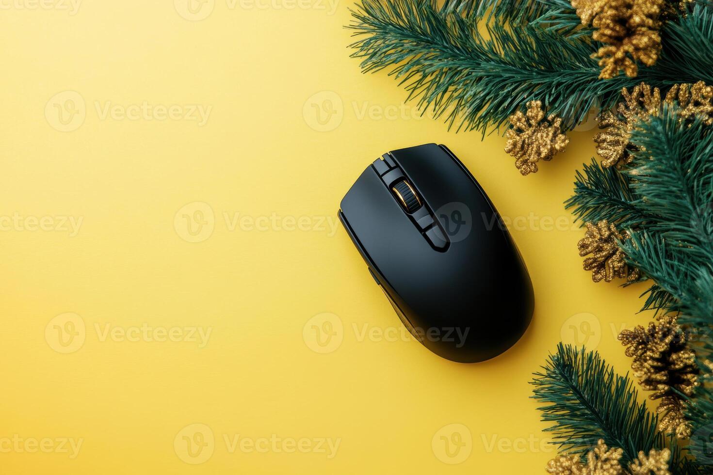 Black computer mouse on yellow background with pine branches creating festive modern tech holiday theme photo