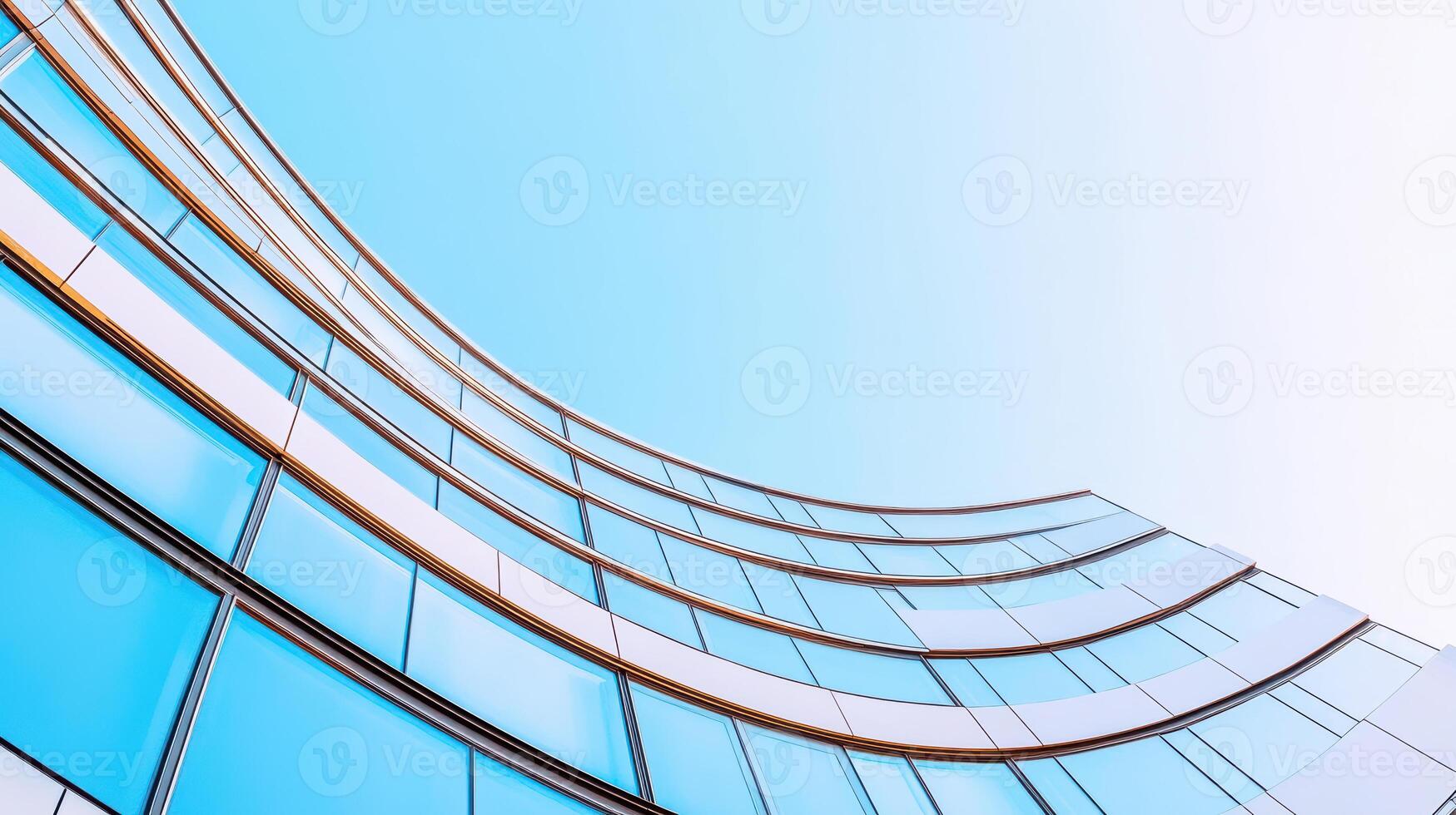 Modern glass building facade reflecting clear blue sky with curved architectural design photo