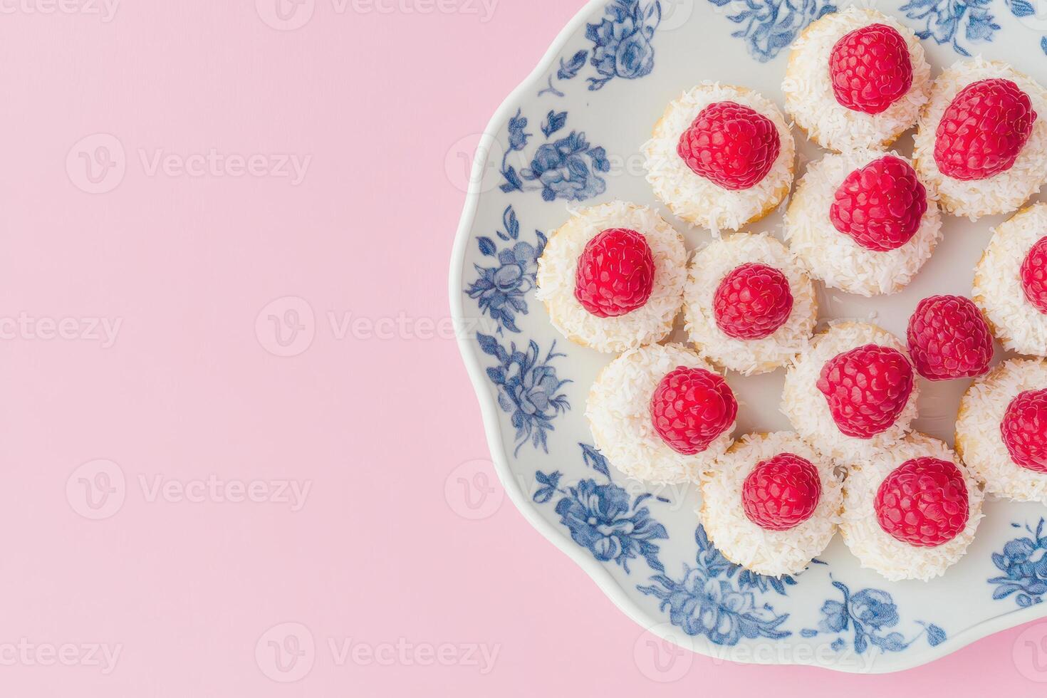 Elegant dessert plate with coconut raspberry bites on a floral patterned dish against a pink background photo