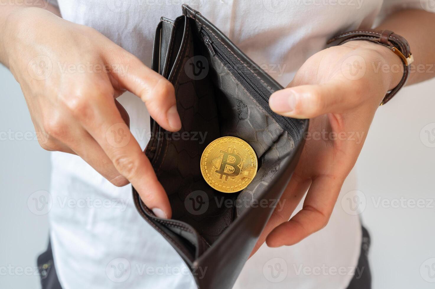 Close up of someone open wallet for showing just one Bitcoin token inside. photo