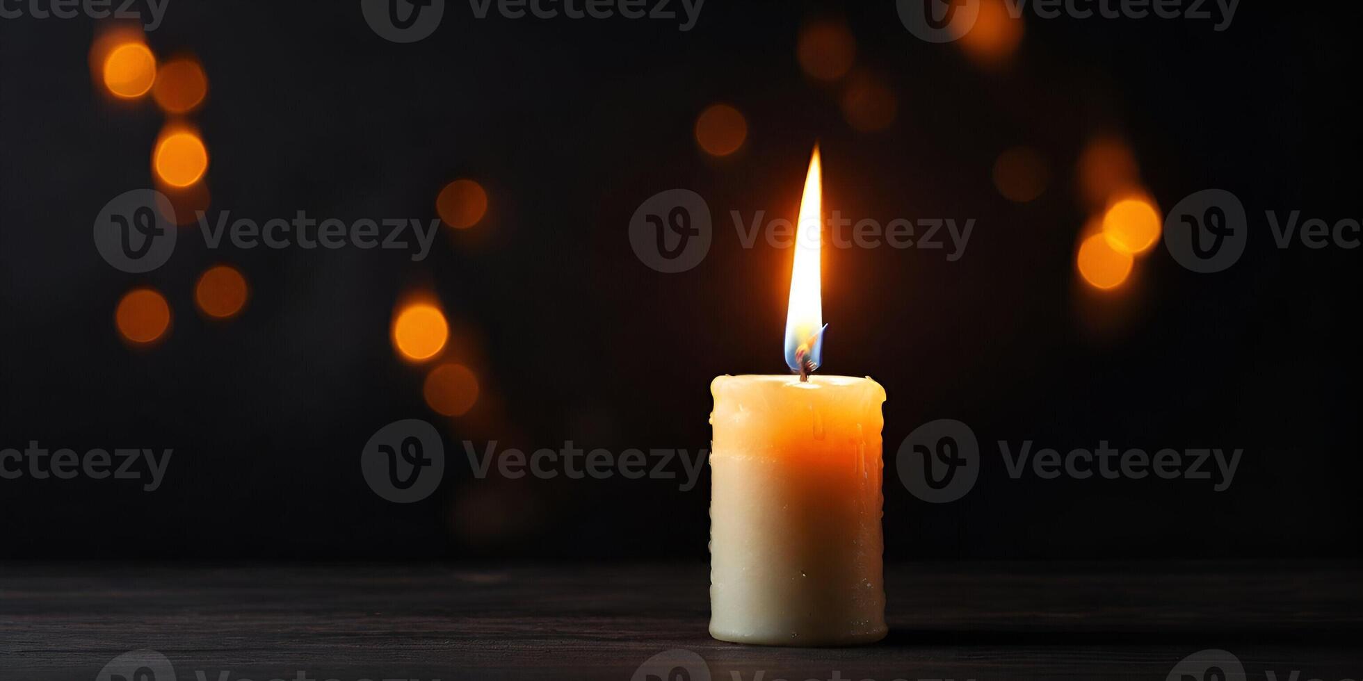 A single candle is lit on a table photo