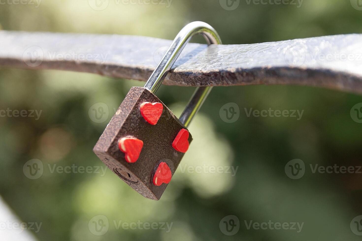 Padlock on a bridge depicting hearts photo
