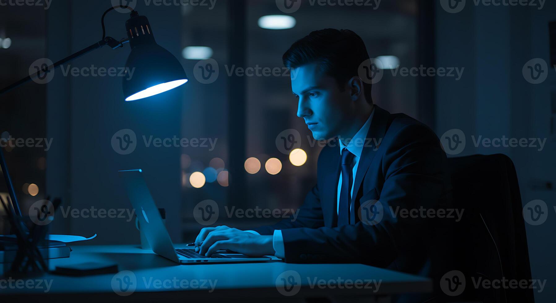 Focused Businessman Working Late Night Office Scene in Cool Blue Light photo