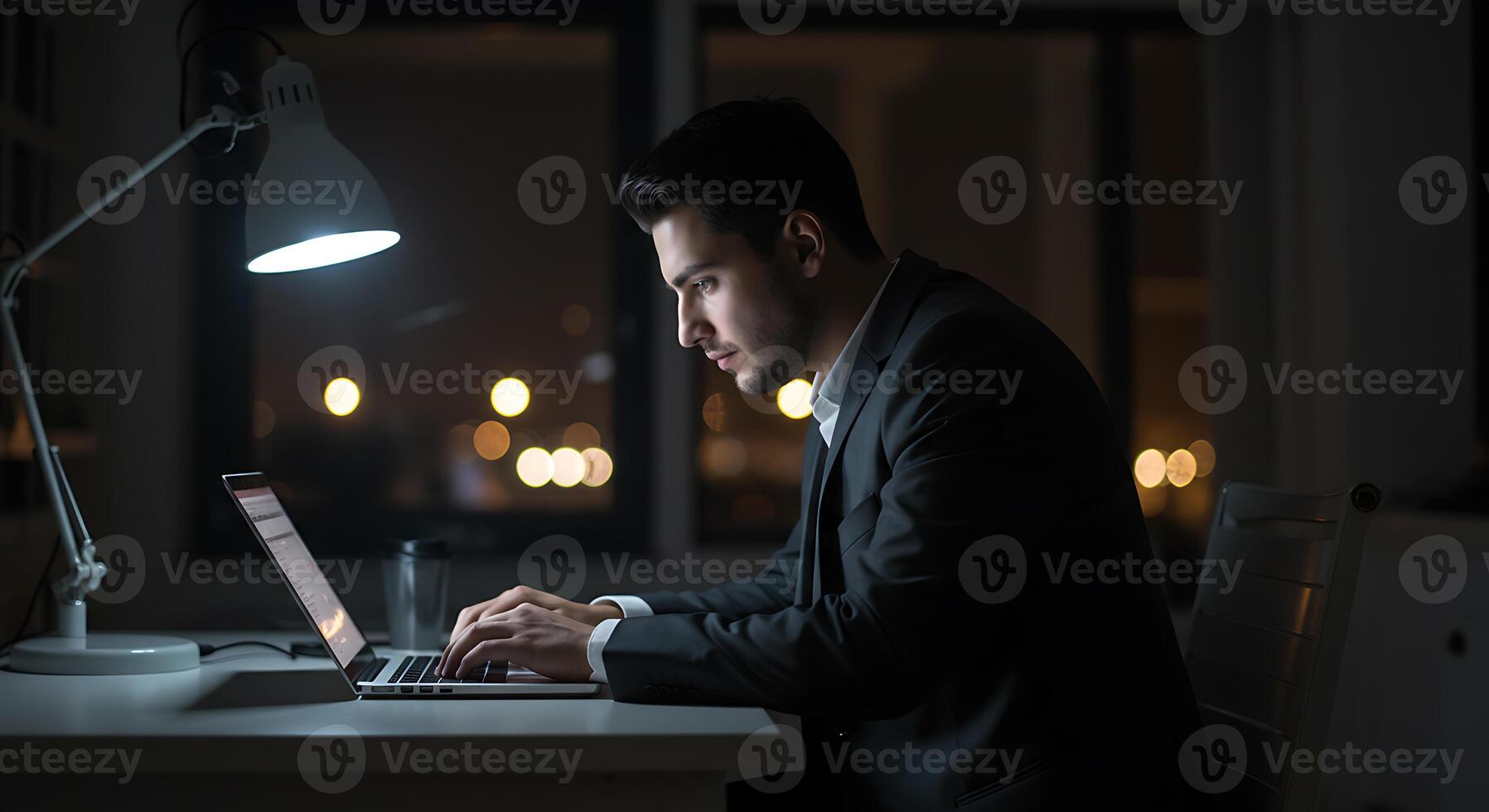 Focused Man Working Late Nighttime Laptop Use Dramatic Lighting photo