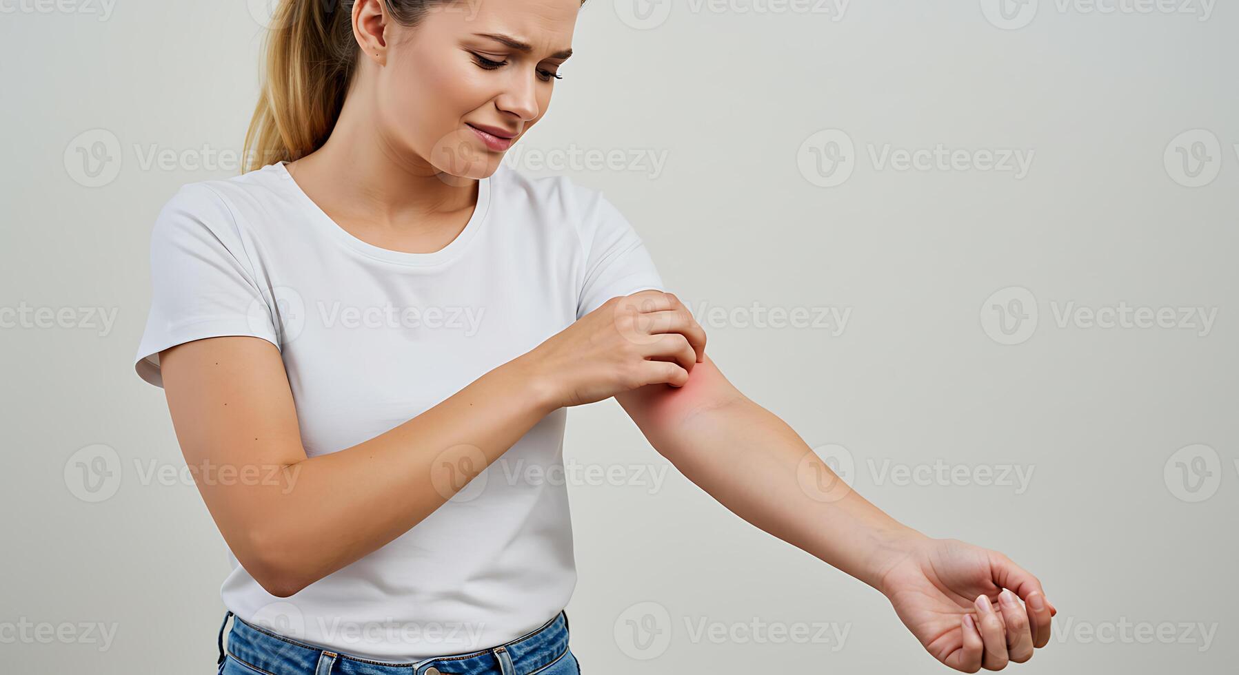 A woman is holding her arm and looking at it photo