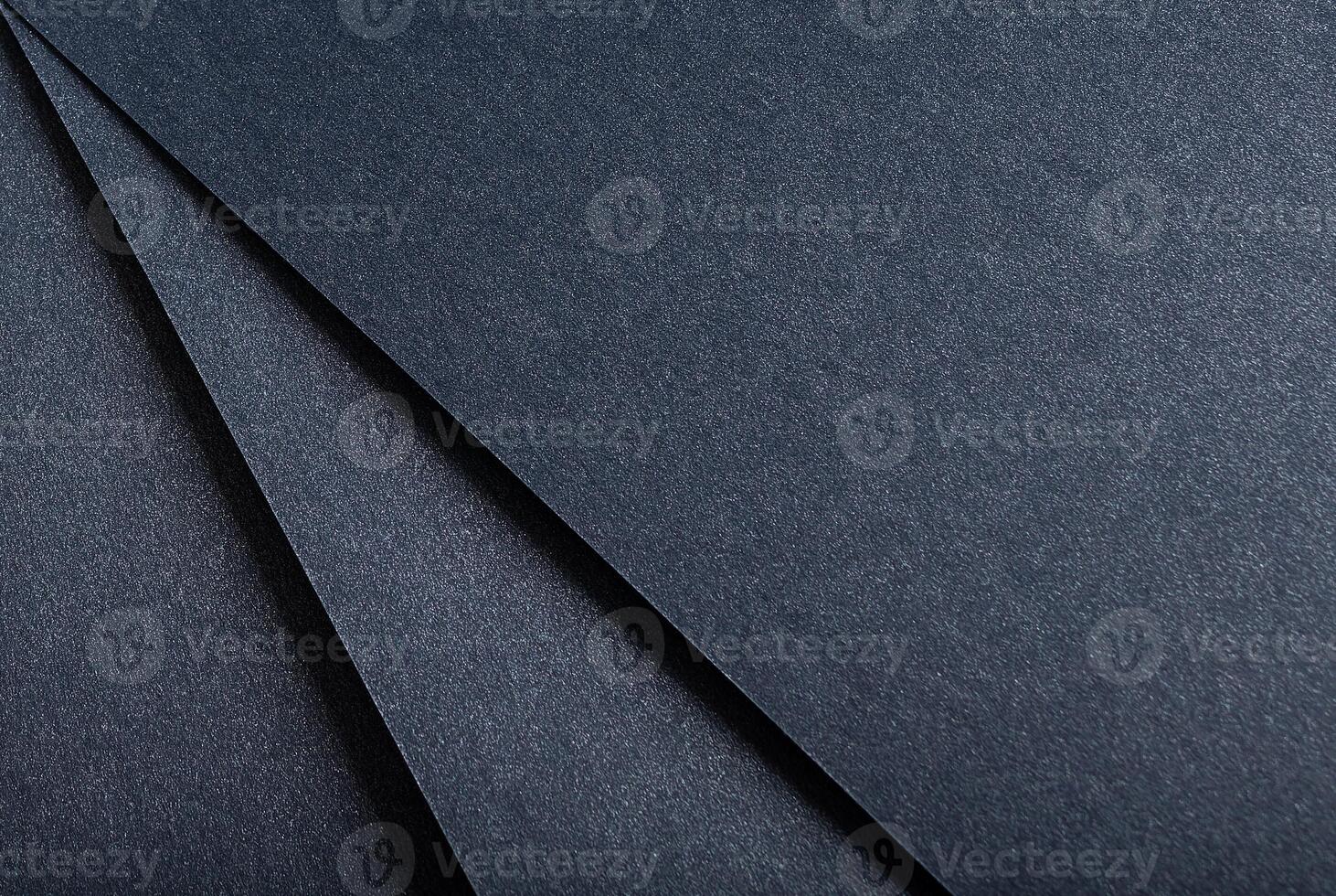 Dark blue paper background with a sleek, glossy texture and a shimmering finish. Elegant, modern photo