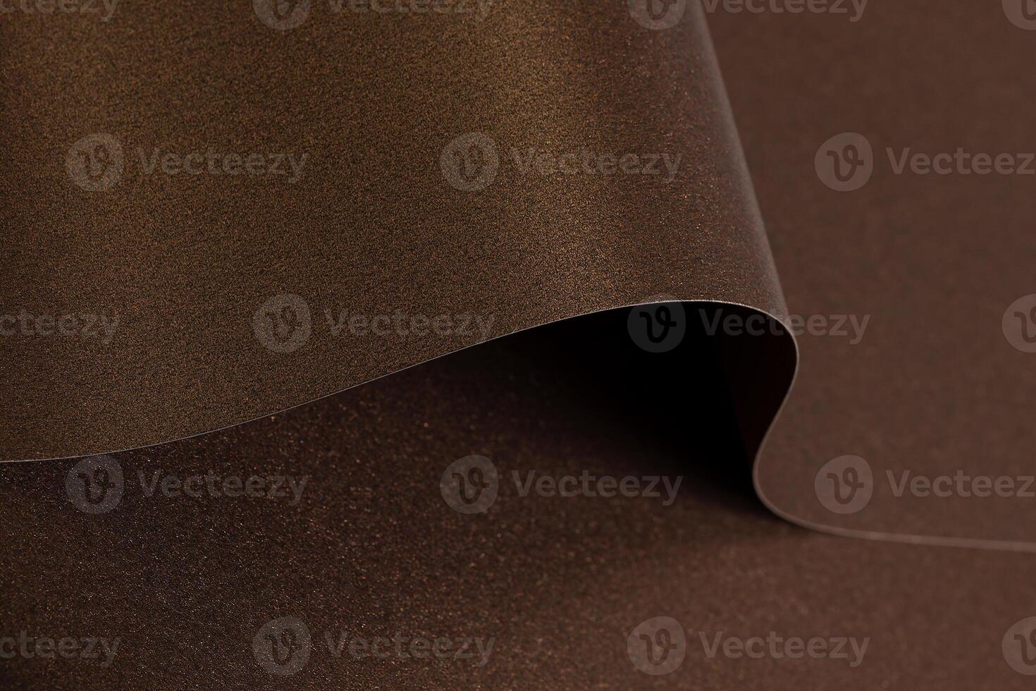 Rich brown paper background with a smooth, glossy texture and metallic bronze shimmer. Elegant waves photo