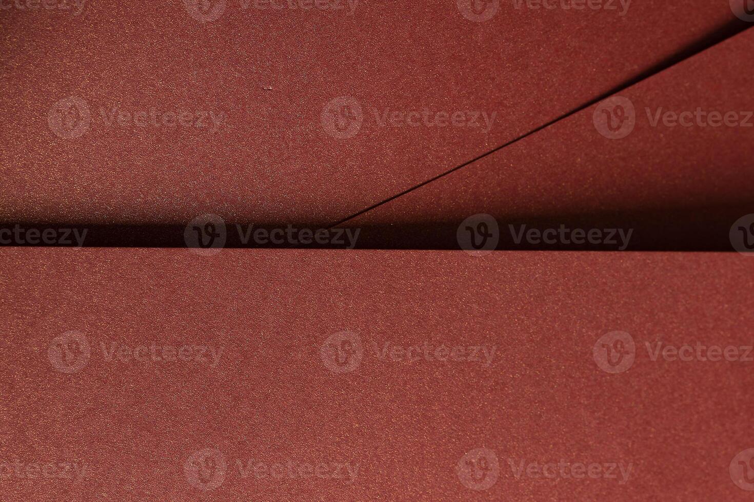 Burgundy paper background with a smooth texture and a metallic, glossy finish. Rich, warm tones photo