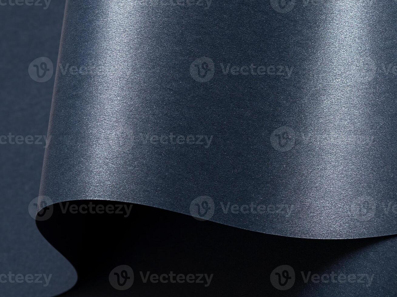 Dark blue paper background with a smooth, glossy texture and metallic shimmer. Cool, rich tones photo