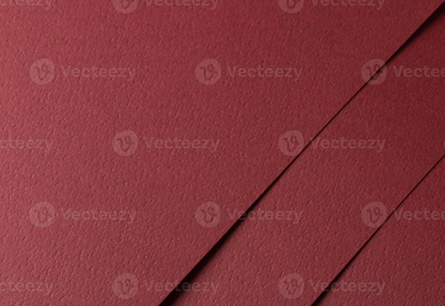 Deep burgundy paper background with a matte texture and fine, tactile surface. Warm red tones create photo