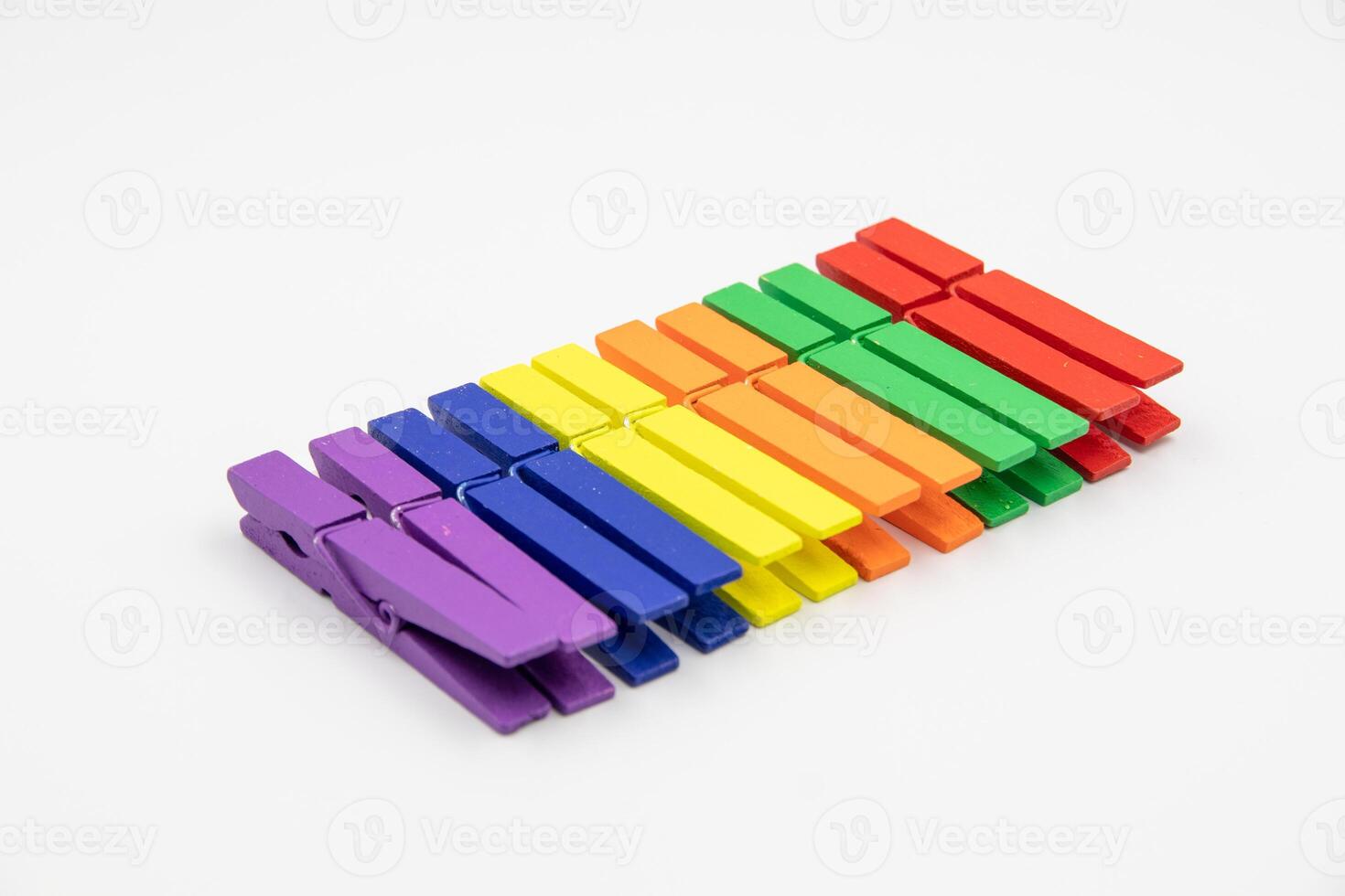 colorful household wooden clothes pins on white background. photo