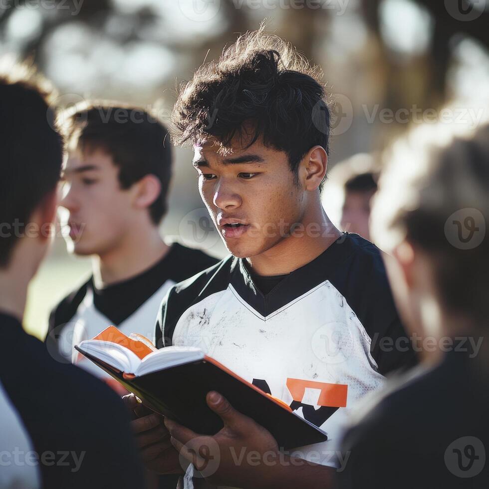A man is reading a book while standing in a group of people photo