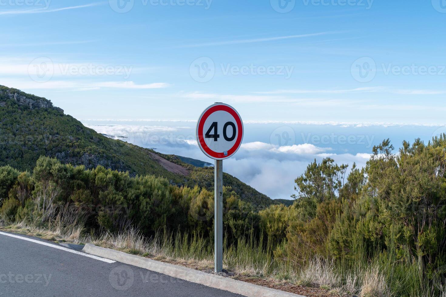 Road Through Green Hills with Traffic Sign photo