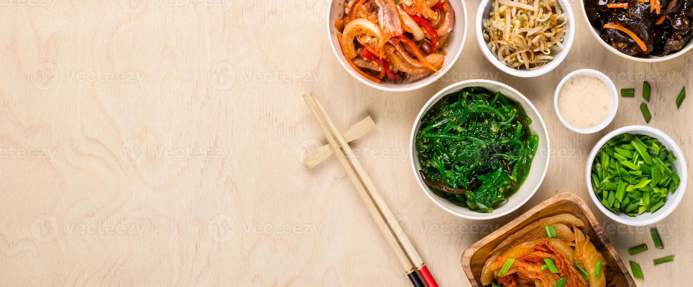 Korean food and chopsticks on wooden background, banner format photo