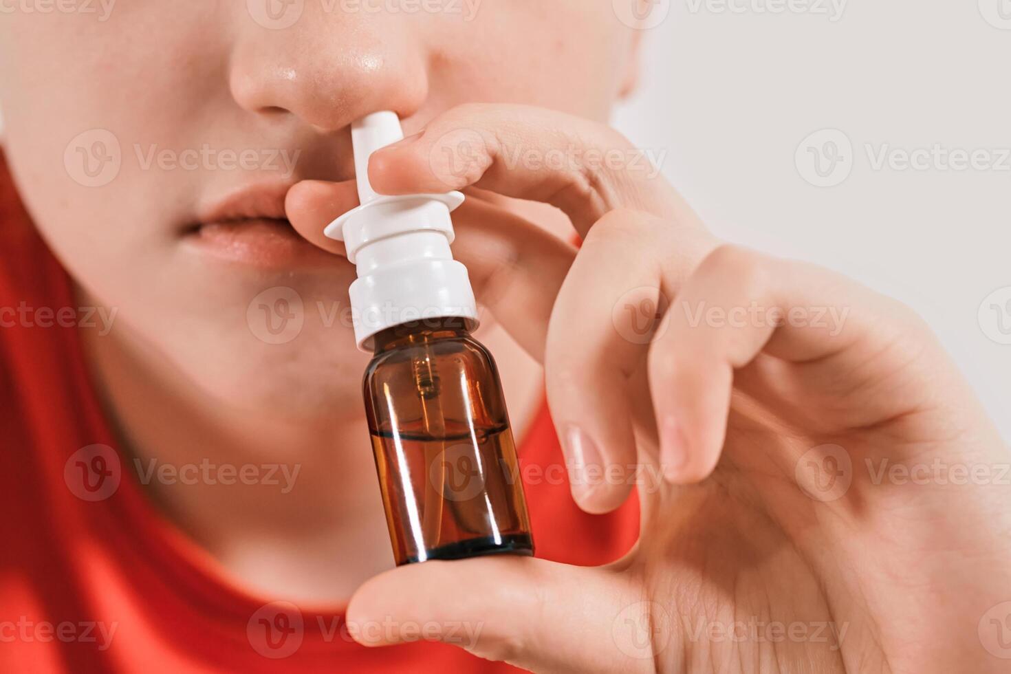 Boy drips nose drops from runny nose. Treatment of colds and allergic rhinitis photo