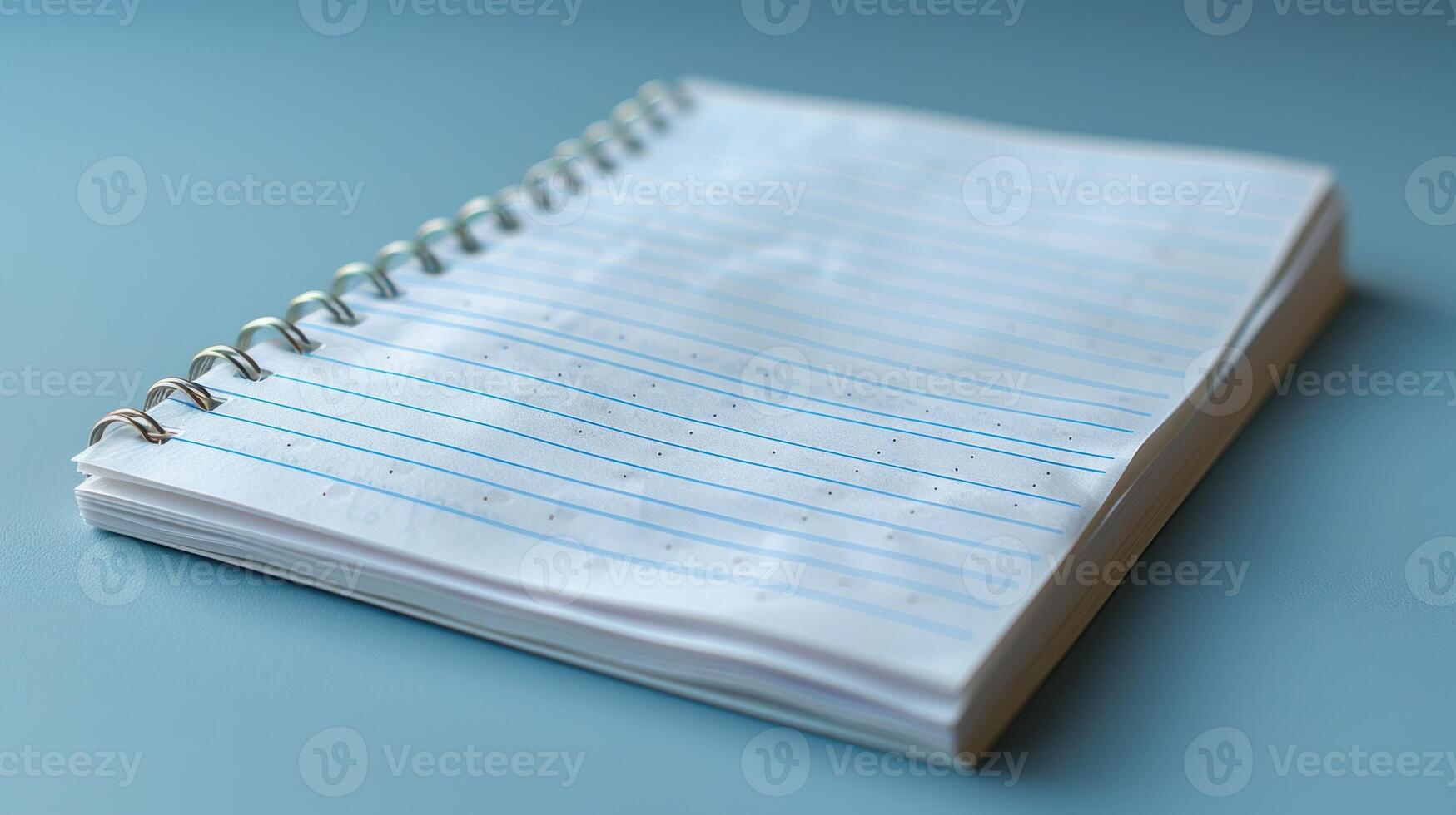 Blank spiral-bound notebook on a light teal surface. photo