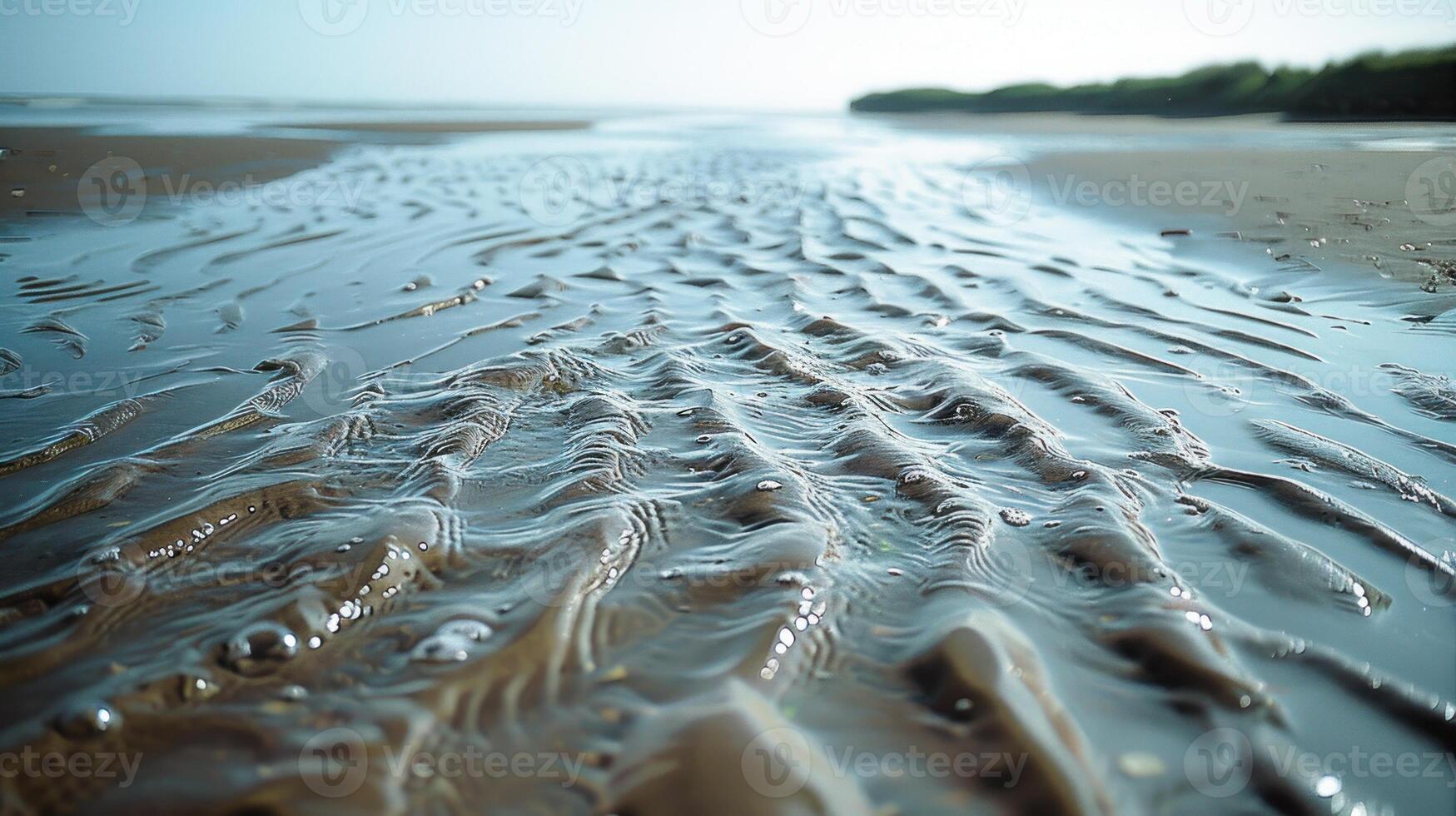 Shallow, rippled water patterns on a sandy beach. photo