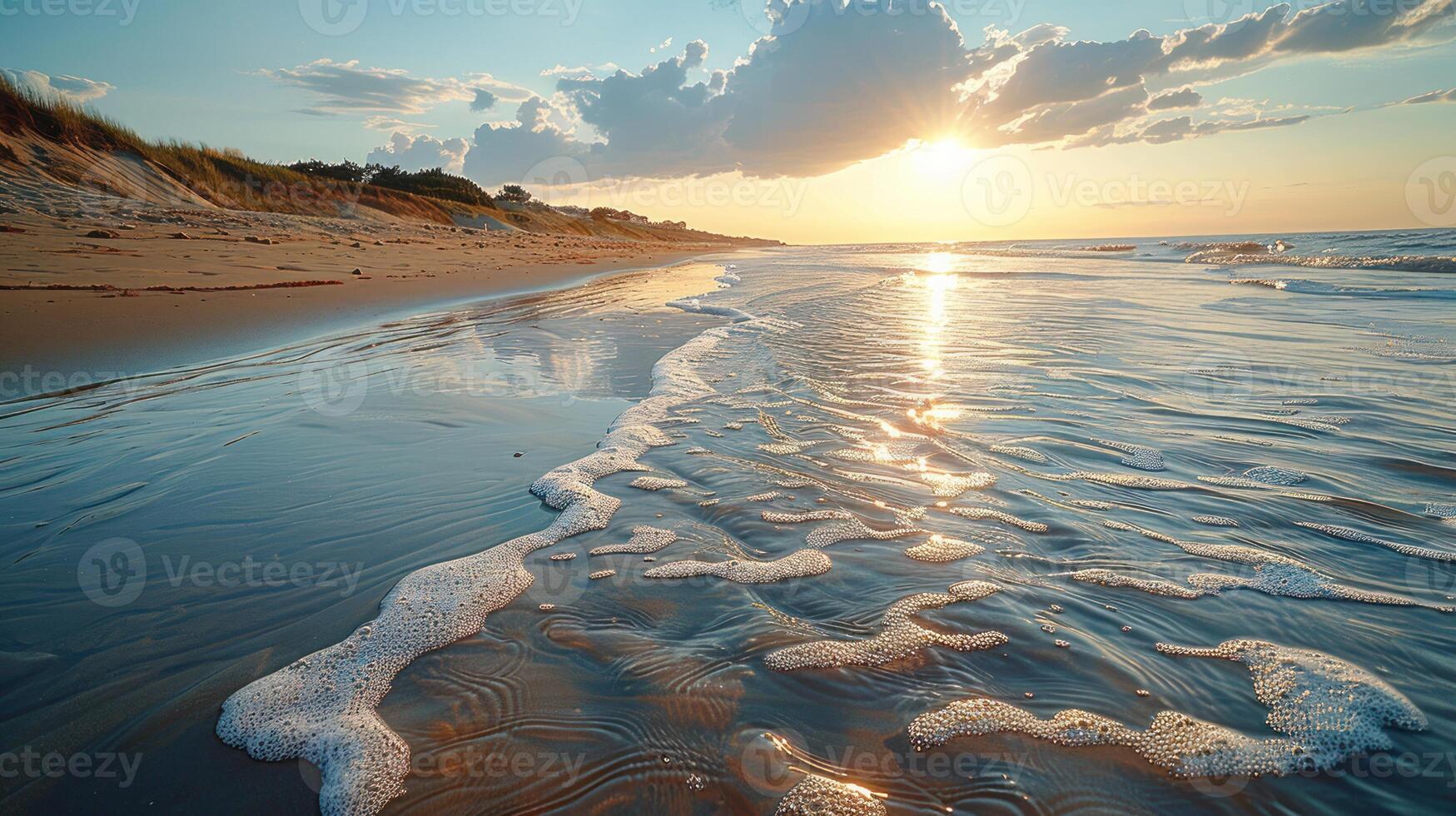 Sandy beach at sunset, waves lapping the shore, tranquil seaside scene. photo