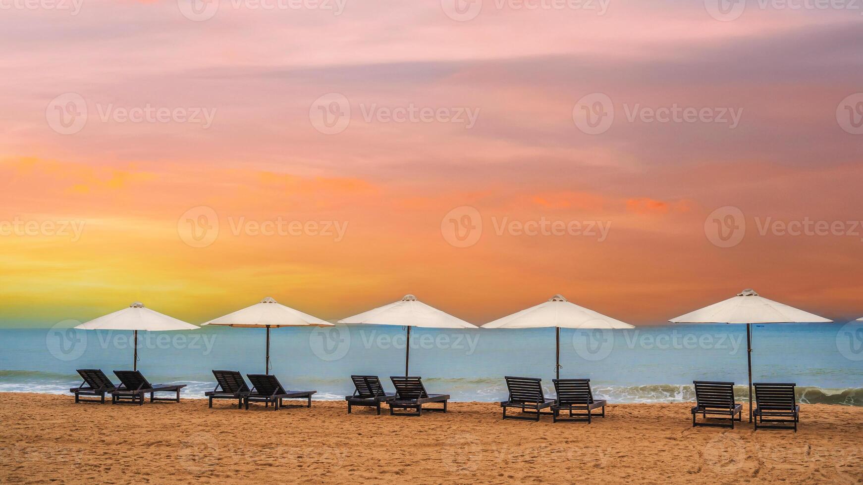 Panoramic Scenic view of the sandy beach with umbrellas and sun beds on the coastline. photo