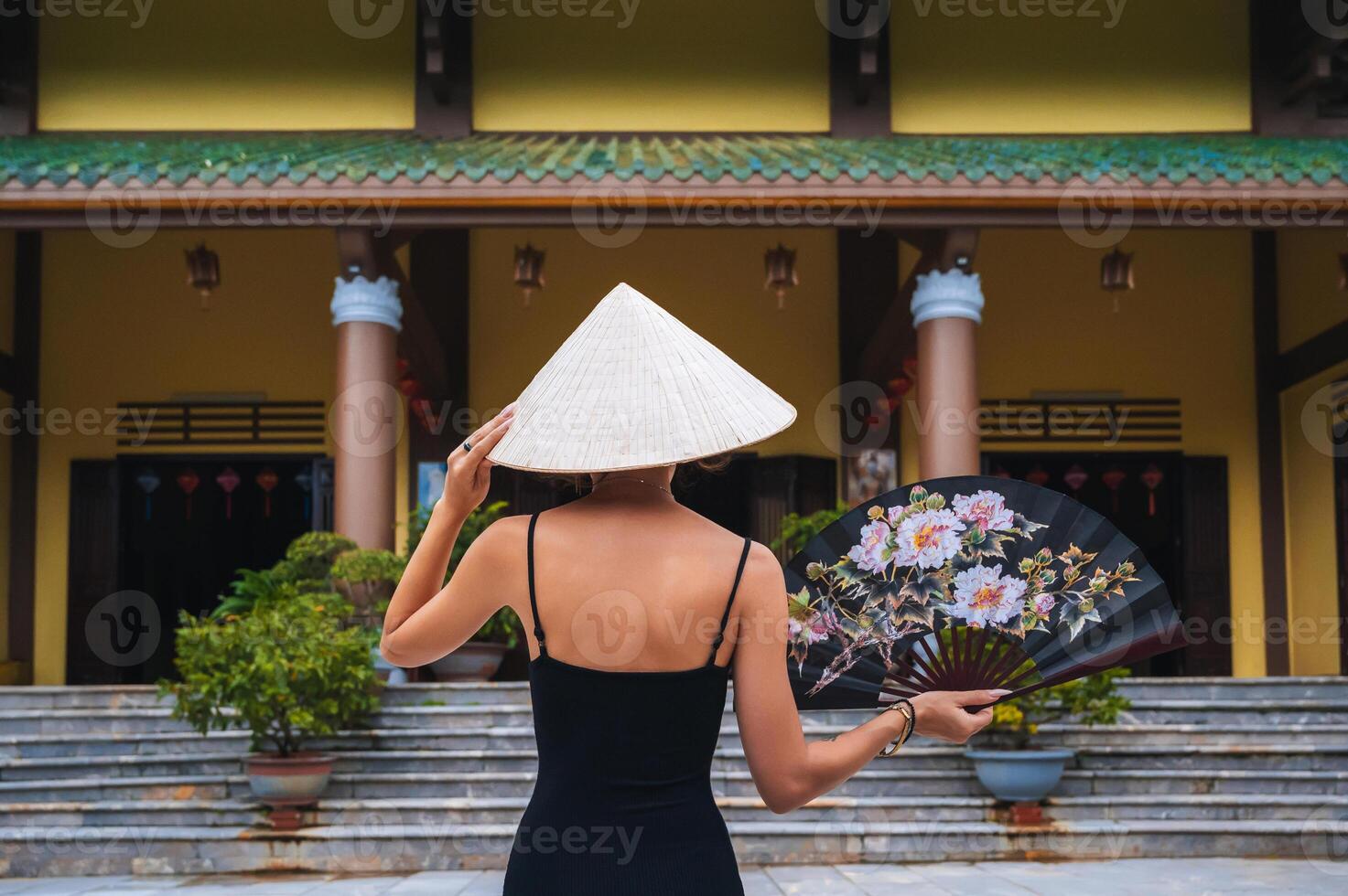 A tourist woman in a Non La hat on the background of beautiful landscapes at the Linh Ung Son Tra pagoda in Da Nang. photo