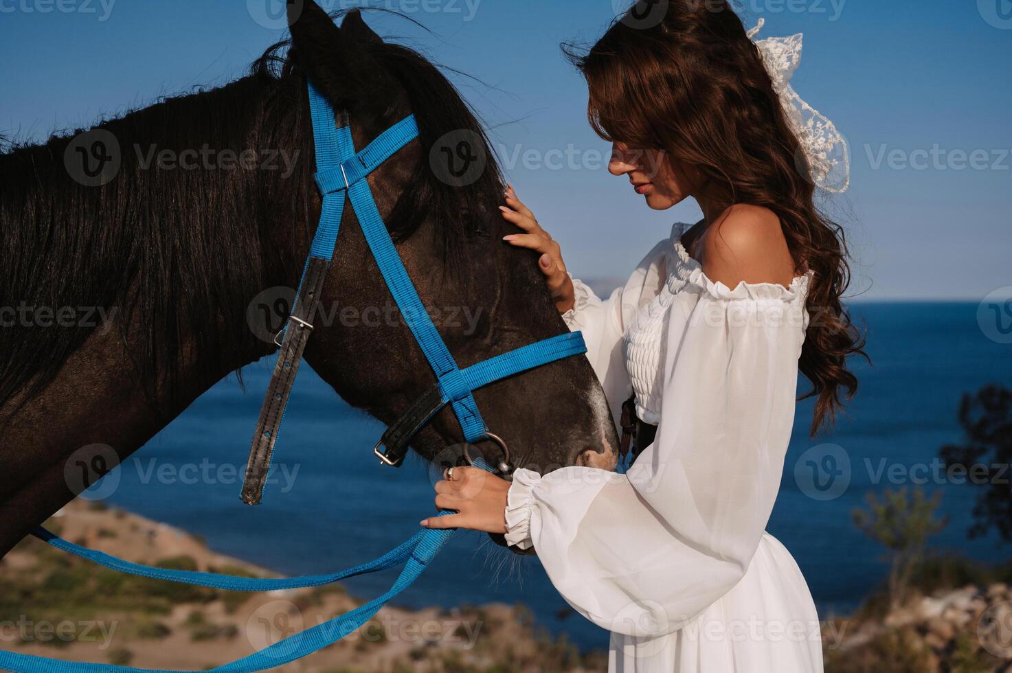 Close-up. A romantic girl hugs her horse against the backdrop of a mountain-sea landscape. The concept of riding. Artistic photography. Ready-made cover for books and magazines. photo