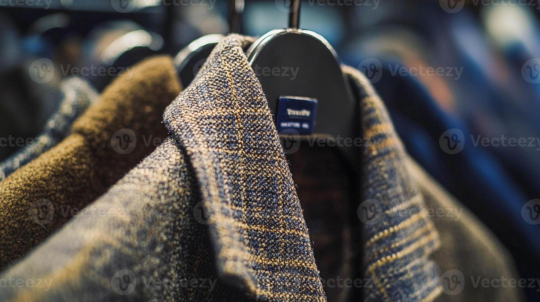 A close up of a coat rack with several coats photo