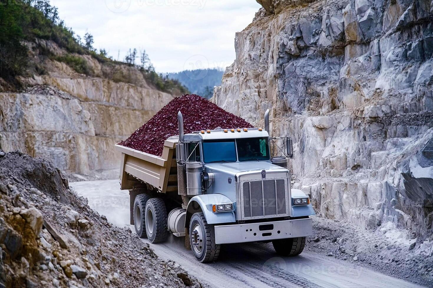 A dump truck is driving down a dirt road photo