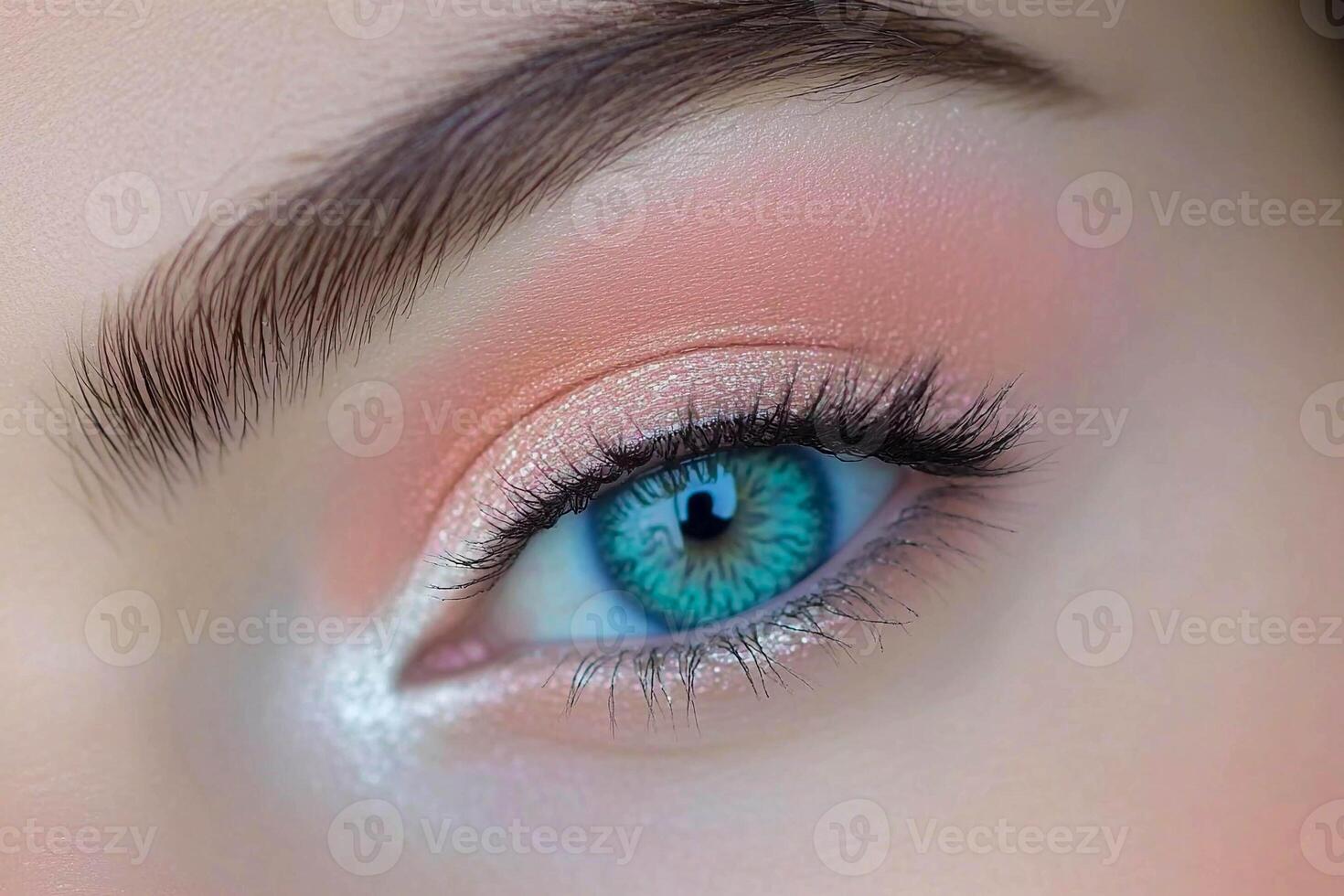 Close-up of a woman's eye showcasing vibrant blue iris and subtle coral eyeshadow during a makeup application photo