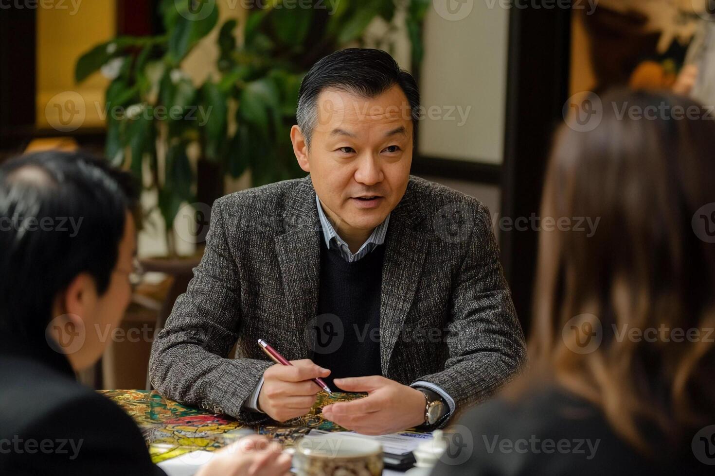 A man sitting at a table with two other people photo