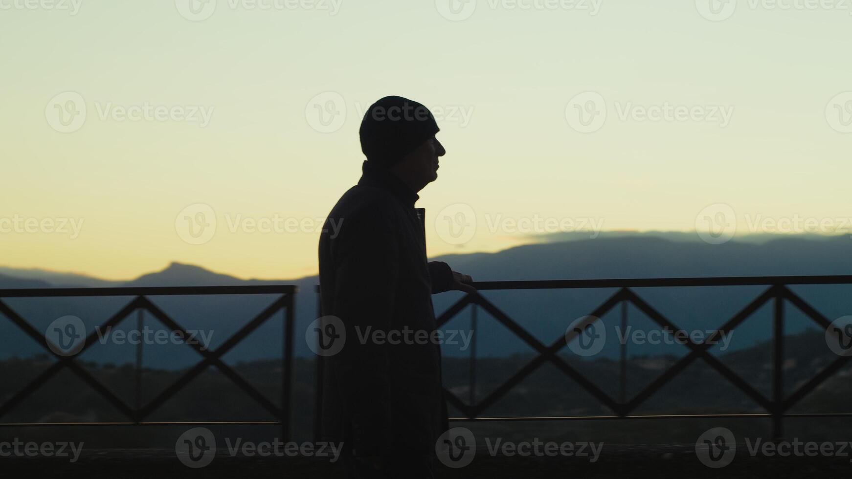 Silhouette Of An Elderly Gentleman Explores A Mountain Balcony At Sunset photo