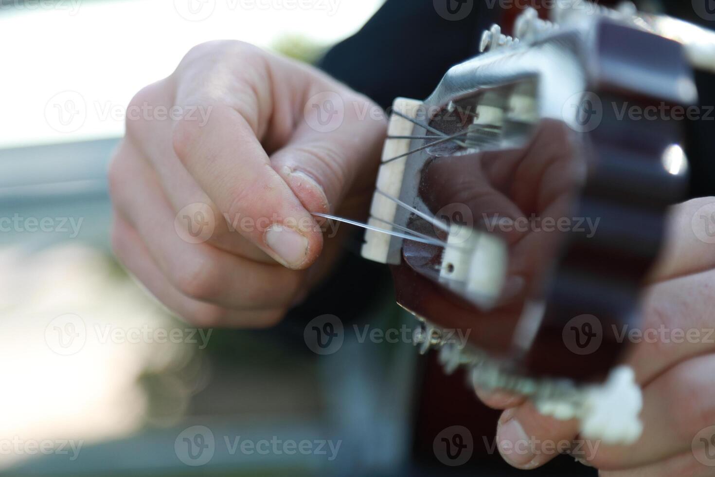 Hand Boy Turns Wrench For Manual Tuning Of Classical Guitar photo