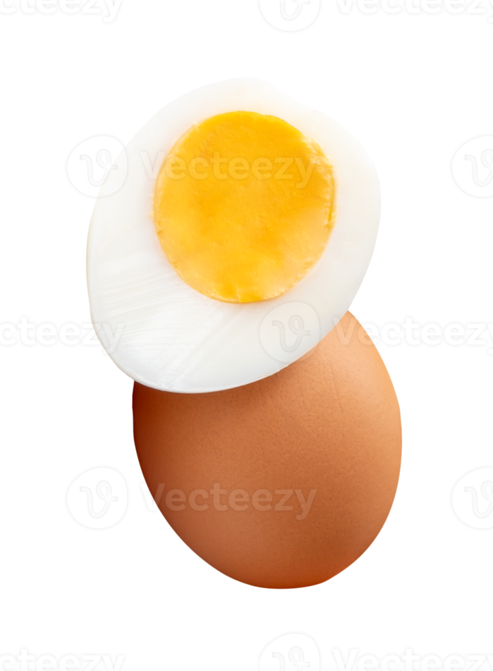 Raw brown chicken egg and cooked or boiled chicken egg with egg yolk in half in small pile isolated with clipping path in file format png